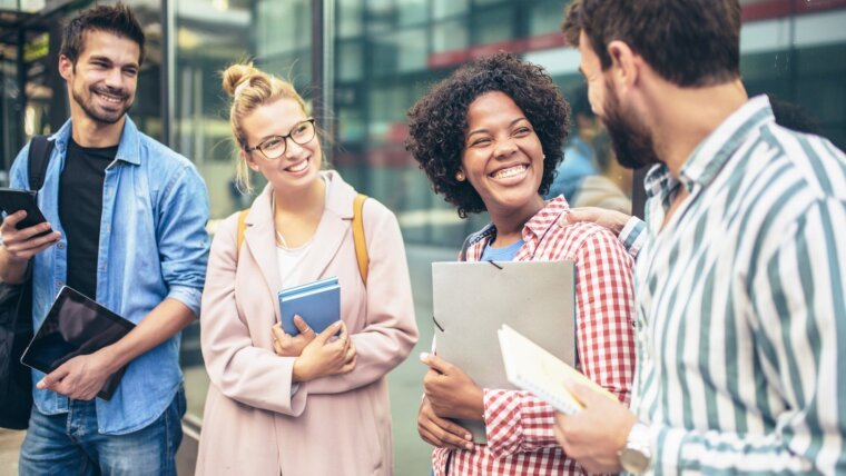 Gruppe von vier internationalen, lächelnden Studierenden.